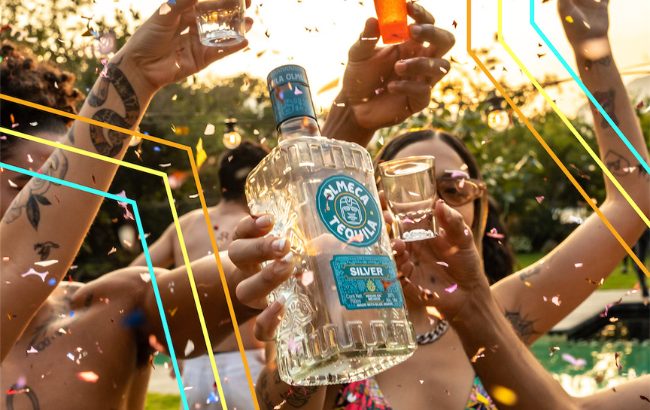 A group of people raising shot glasses and a bottle of Olmeca Silver Tequila in an outdoor celebration, with confetti and colorful lines overlaying the festive scene.